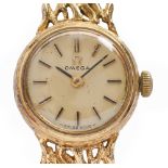 An Omega 9ct gold lady's wristwatch, 17mm diam, on 9ct gold bracelet of cast openwork links, 18.