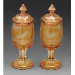A pair of Bohemian amber flashed and wheel engraved goblets and covers, 19th c or later, with a