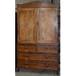 A George IV mahogany linen press, the triangular pediment above pair of panelled doors with brass