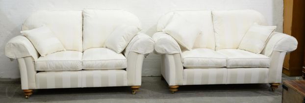 A pair of modern chesterfield sofas, in white stripe upholstery, on light wood bun feet with brass