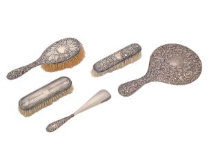 A George V silver hand mirror, by J & R Griffin, Chester 1917, three silver brushes and a silver