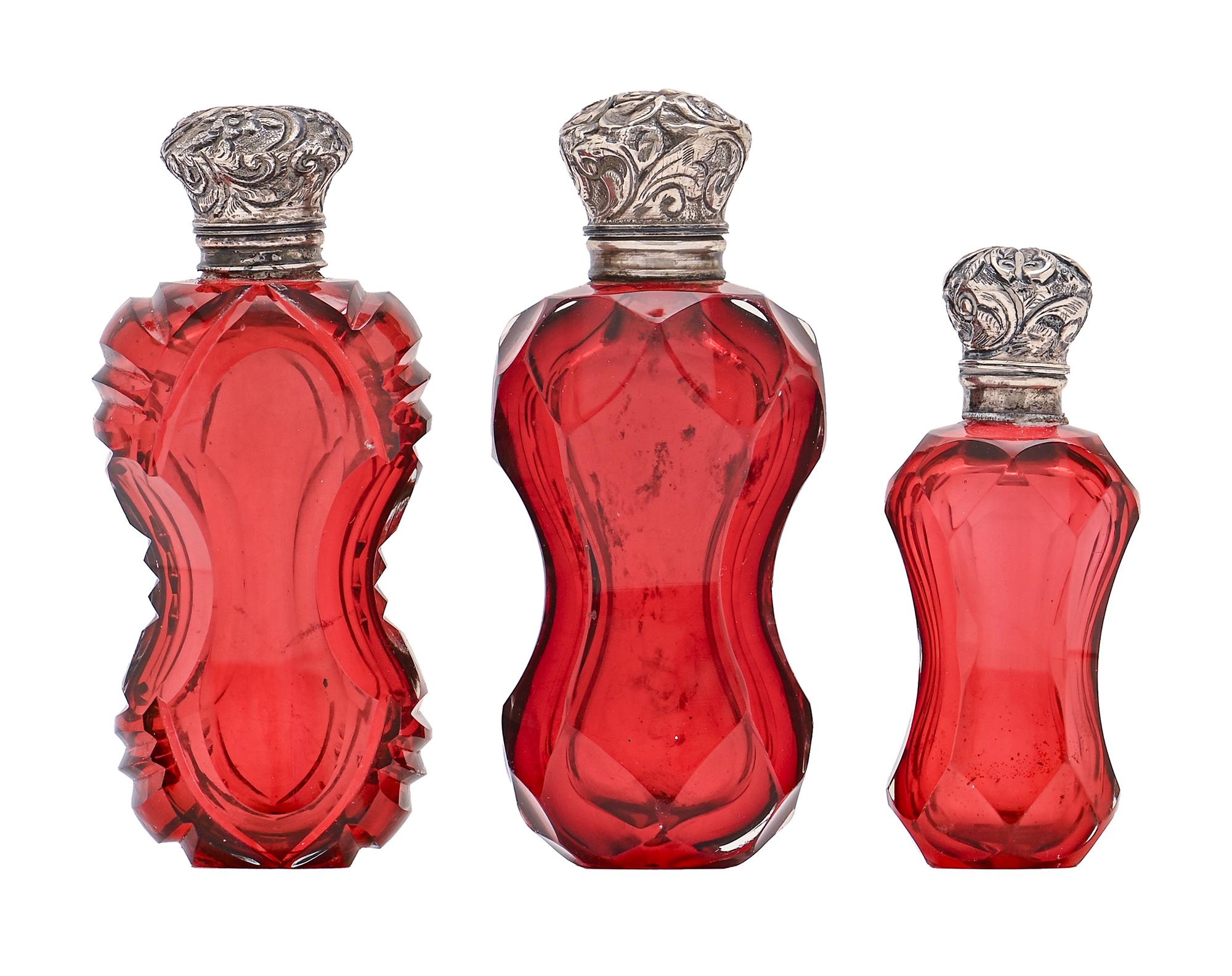 Three similar Victorian silver mounted ruby glass scent bottles, of waisted form, two with