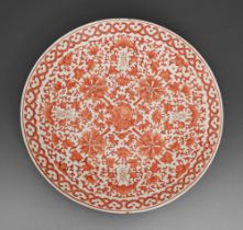 A Chinese porcelain dish, late 19th c, painted in red monochrome with lotus, peaches and gilt shou