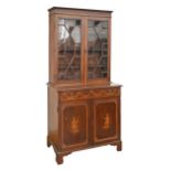 An Edwardian mahogany, satinwood and inlaid bookcase, the panelled doors to the lower part decorated