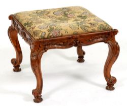 A Victorian carved walnut stool, with woolwork seat, 45cm h; 59cm w Minor shrinkage cracks to frame,