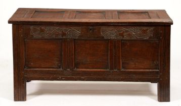 A late 17th or early 18th c panelled oak blanket box, the front top rail carved with thistles, the