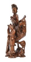 A Chinese rootwood carving of Guanyin on a phoenix with attendant, early 20th c, glass bead eyes,