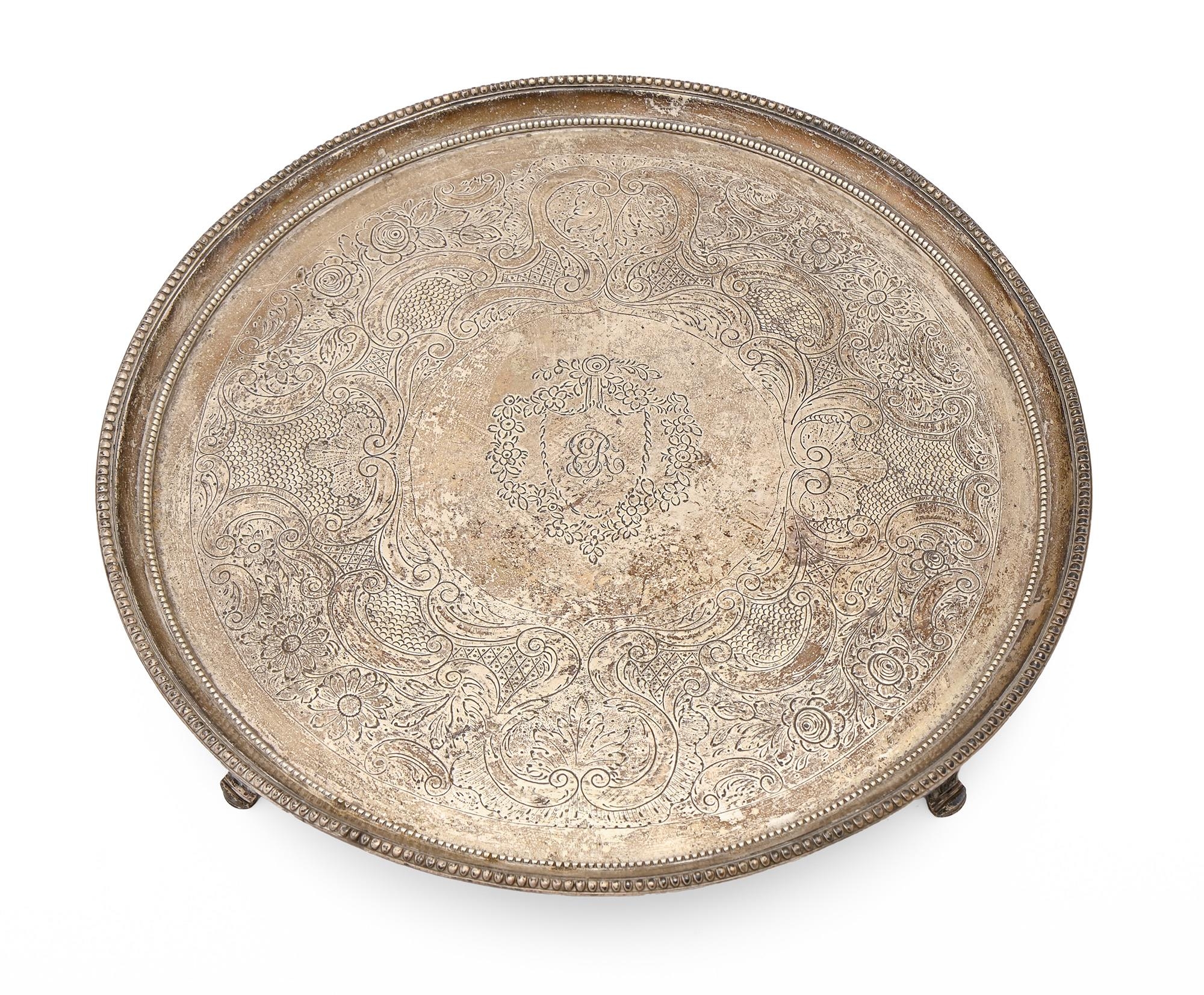 A George III silver salver, with beaded rim, on four fluted feet, later chased, 33cm diam, by Daniel