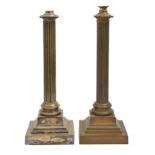 Two similar Edwardian brass or plated columnar oil lamps, the reeded shaft on stepped square foot,