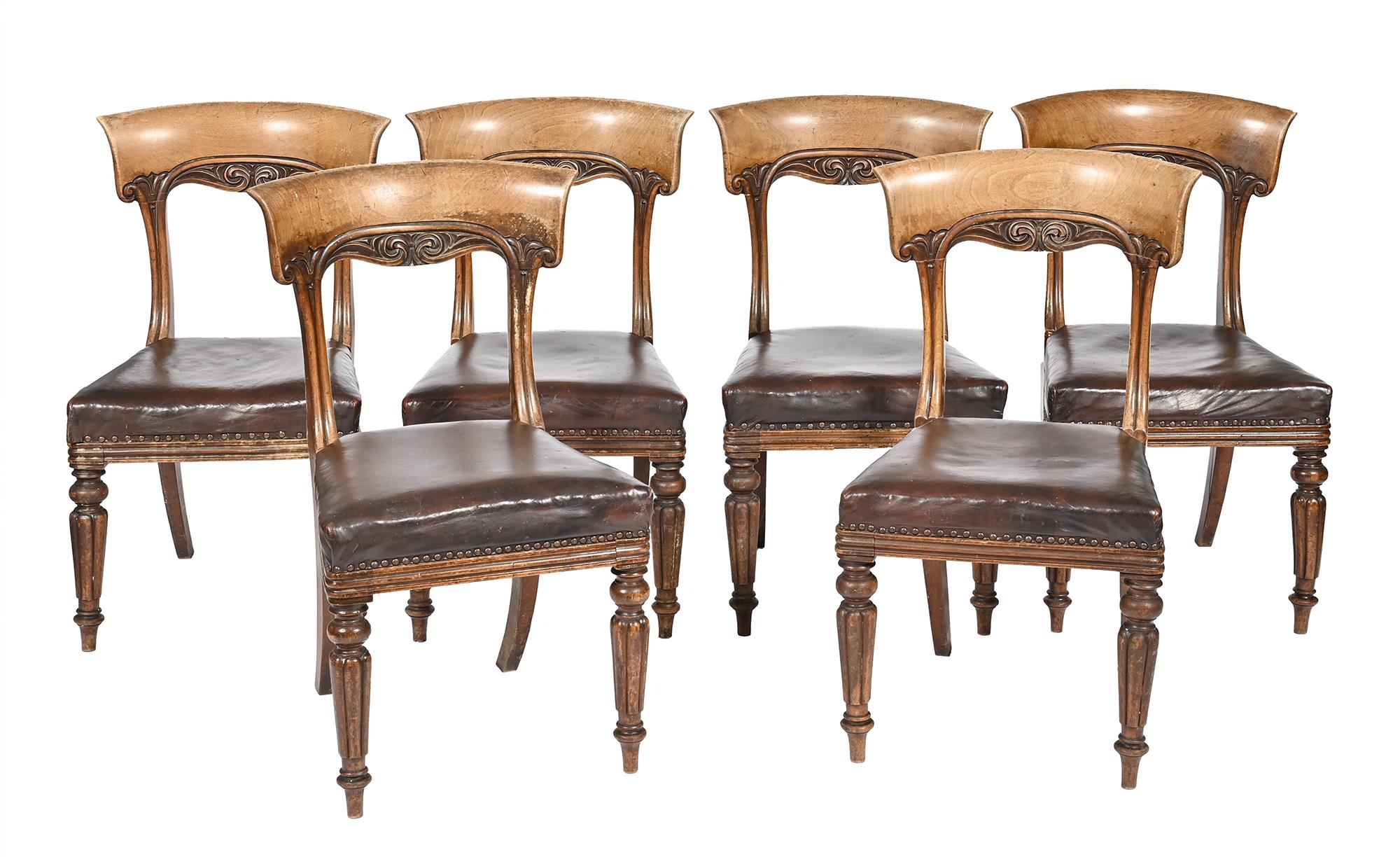 Six Victorian carved walnut dining chairs,  on reeded front legs, the seats with brown nailed