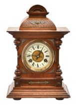 A German walnut mantel clock, c1900, with primrose enamel chapter ring and gong striking movement,