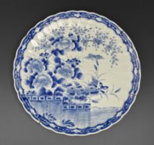 A Japanese fluted blue and white dish, early 20th c, painted with bird and flowers, 47.5cm diam