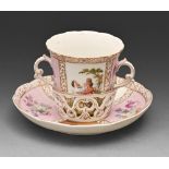 A German porcelain two handled cup and trembleuse stand, c1900, painted with 18th c lovers