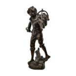 A bronze sculpture of a bare foot French boy carrying a basket of fruit on a pole over his shoulder,