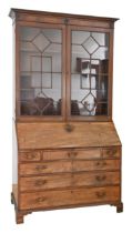 A George III mahogany bureau bookcase, the upper part with glazed doors, the cornice applied with