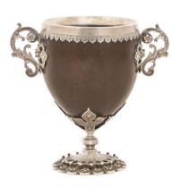 A silver mounted coconut cup, 19th c, with leafy cast floral scroll handles and scalloped rim, on
