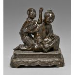 A Japanese bronze group, Meiji period, of a seated man and boy kneeling at his shoulder, mounted