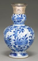 A Chinese blue and white double gourd vase, 18th c, painted with flowering plants in lappet shaped