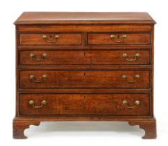 A George III oak and crossbanded chest of drawers, the top with barber pole stringing, fitted two