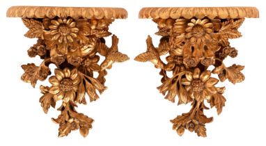 A pair of carved wood wall brackets, 20th c, the semi-circular scalloped shelf on a of a profusion