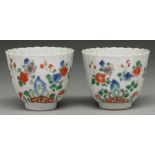 Two Chinese famille verte fluted cups, Kangxi period, painted with flowering plants growing from a