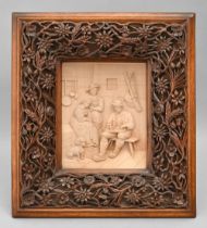 A Swiss limewood diorama of an interior with musician and dog in  carved walnut frame, late 19th