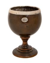 An English coconut cup, late 18th c, with uneven brown patina, silver escutcheon engraved with