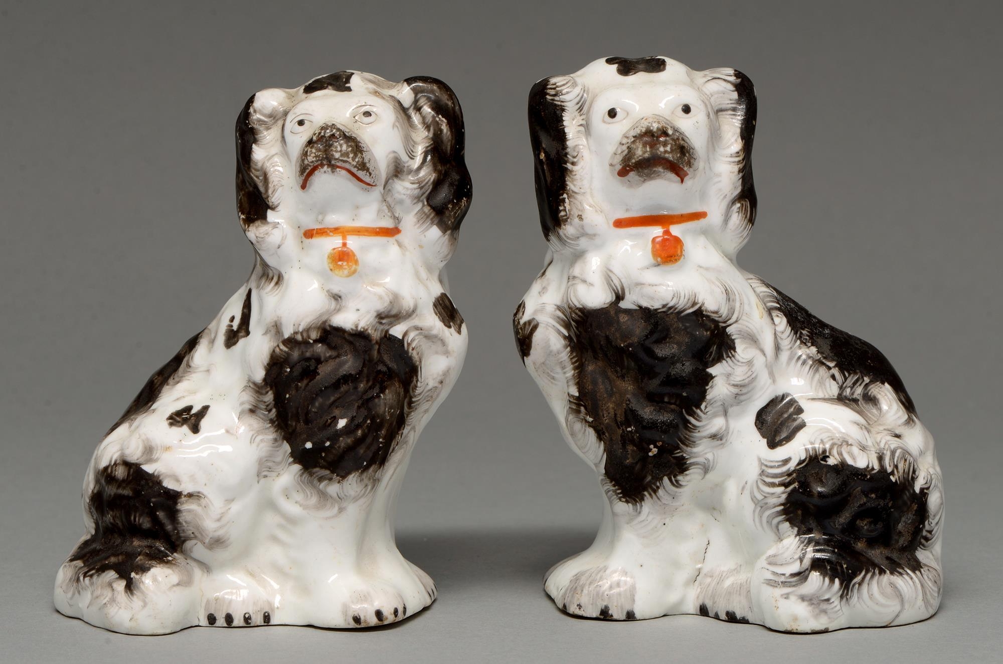 A pair of Staffordshire bone china models of spaniels, c1850, sponged in black enamel, 10.5cm h