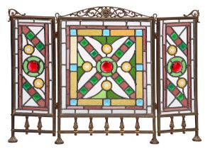 A Victorian brass folding firescreen, c1900, with three leaded polychrome glass lights, 60cm h