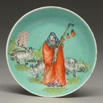 A Chinese turquoise ground dish, late 19th c, painted with a sage and sheep, 95mm diam, Guangzhou