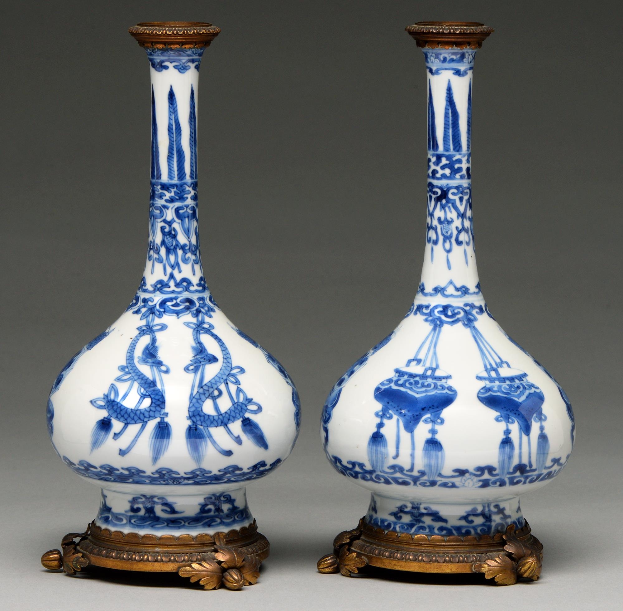 A pair of Chinese blue and white bottle vases, Kangxi period, on flared foot, painted to the central