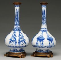 A pair of Chinese blue and white bottle vases, Kangxi period, on flared foot, painted to the central