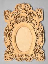 A Chinese carved and pierced wood photograph frame, c1900, the oval aperture framed by a horseshoe