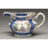 A Chinese underglaze blue and famille rose milk jug, early 19th c, enamelled with square panels of a