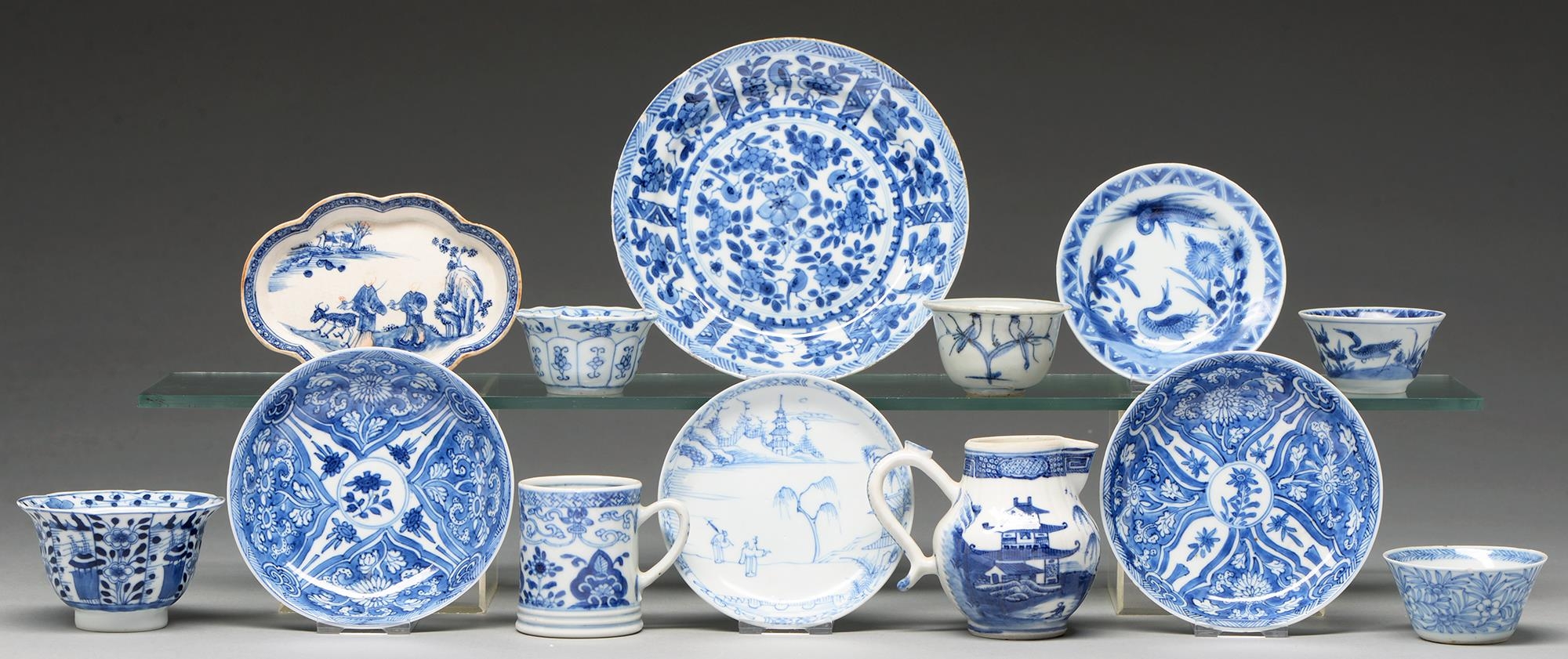 A Chinese blue and white tea bowl and pair of saucers, Kangxi period, saucers 12.7cm diam, conch