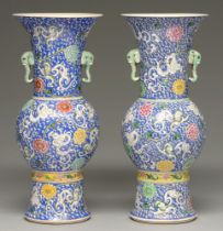 A pair of Chinese blue ground famille verte vases, 20th c, of gu form with elephant head handles,