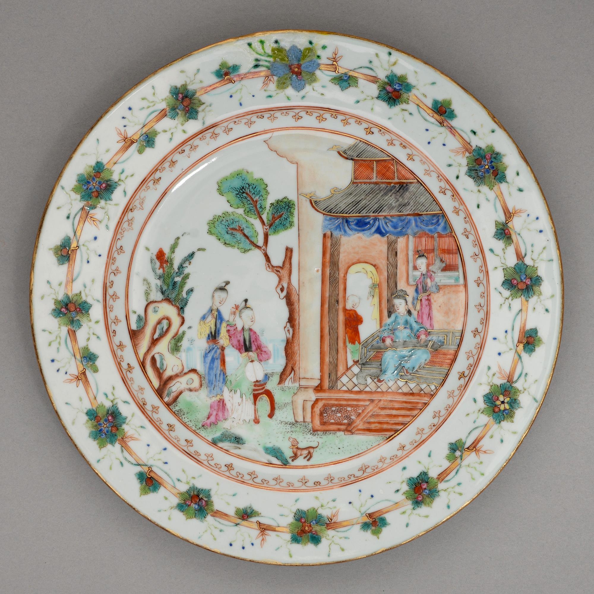 A Chinese famille rose plate, 18th c, enamelled with figures in a building or garden amidst