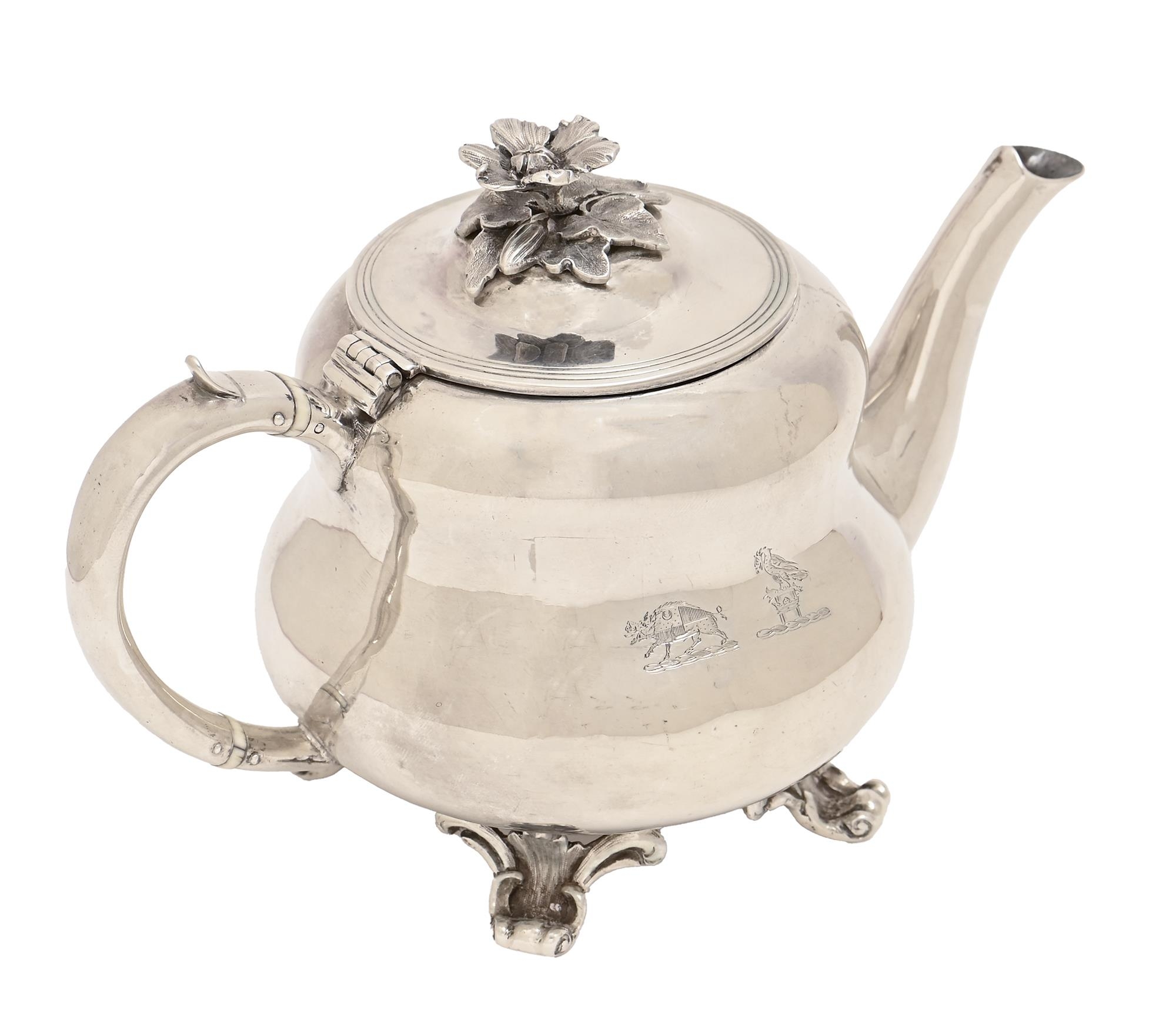 A George IV silver bachelor's teapot, of waisted form with flower knop, on paw feet, crested,