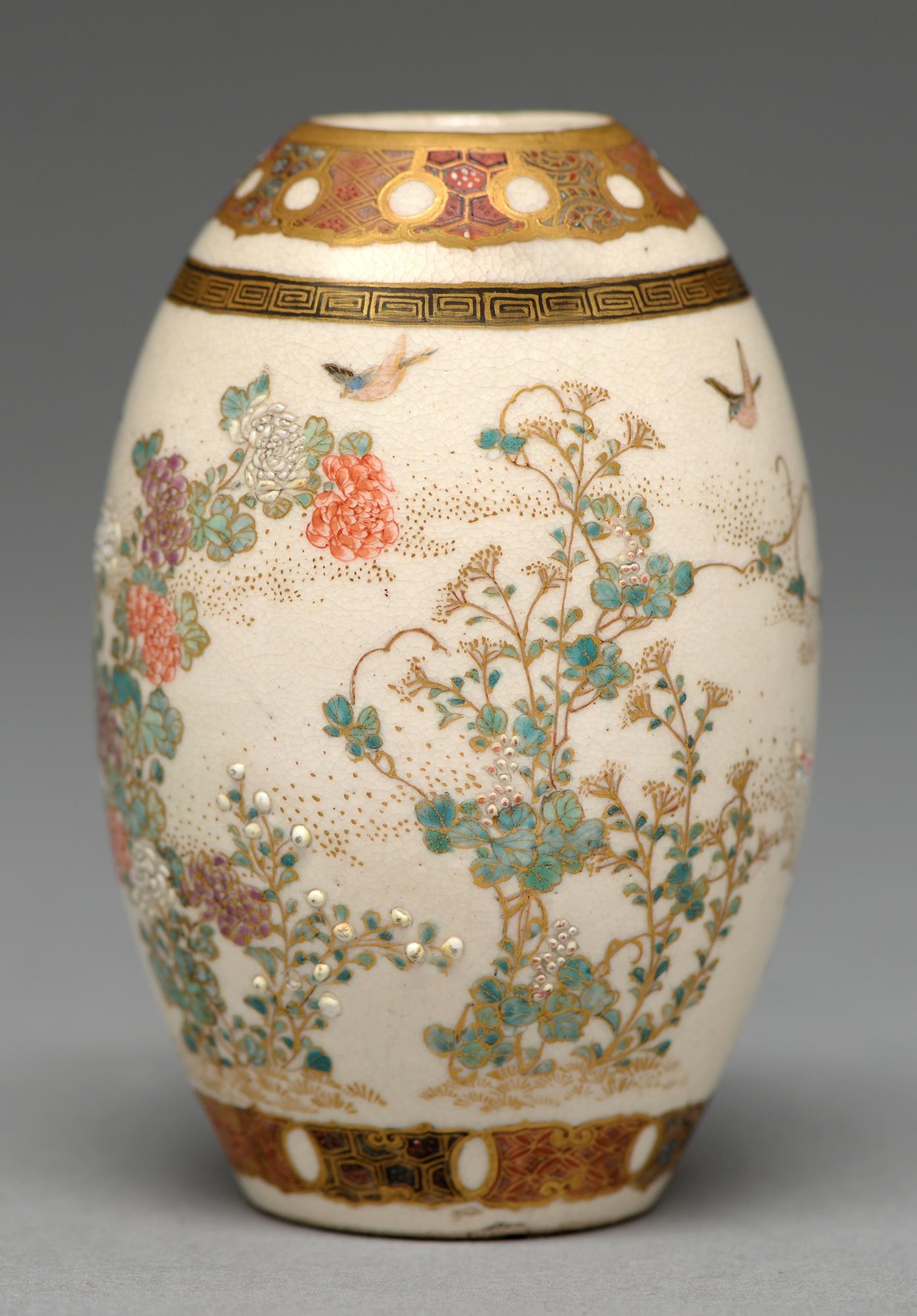 A Satsuma ware drum shaped vase, Meiji period, enamelled and gilt with naturalistic flowering plants