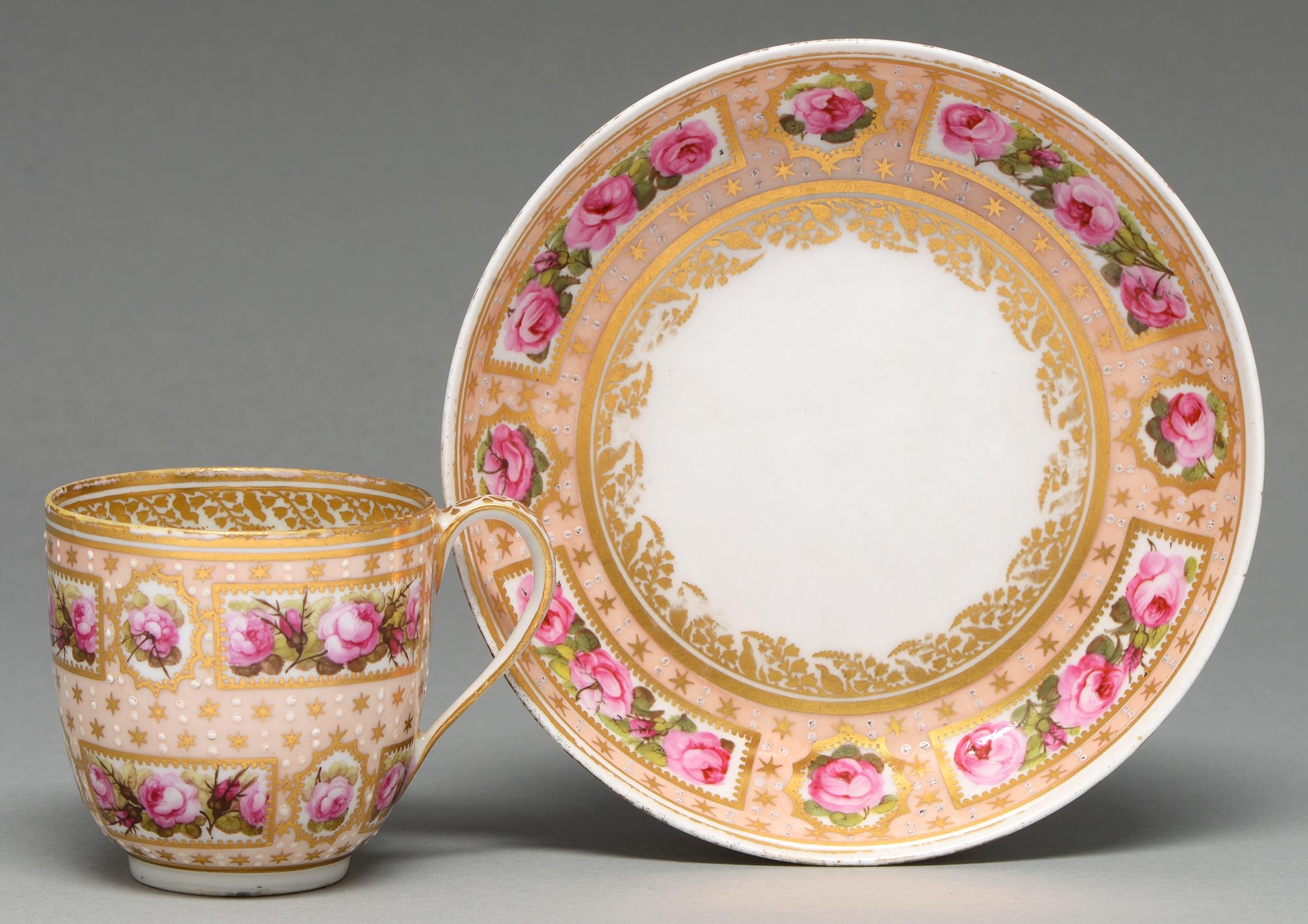 A Derby coffee cup and saucer, c1795, painted with reserves of roses on a salmon pink ground, saucer