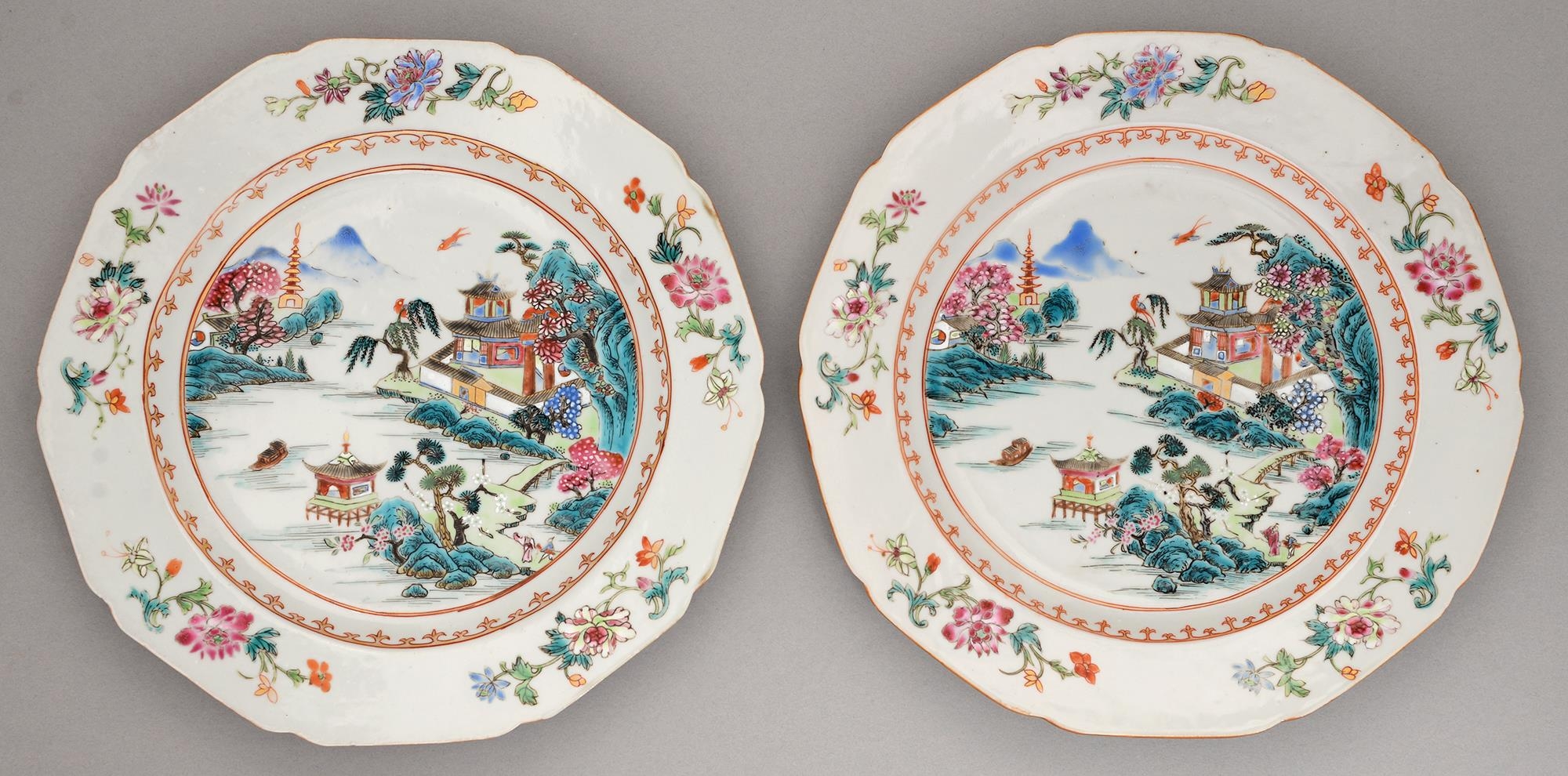A pair of Chinese famille rose plates, c1770, enamelled with a river scene in gilt spearhead cavetto
