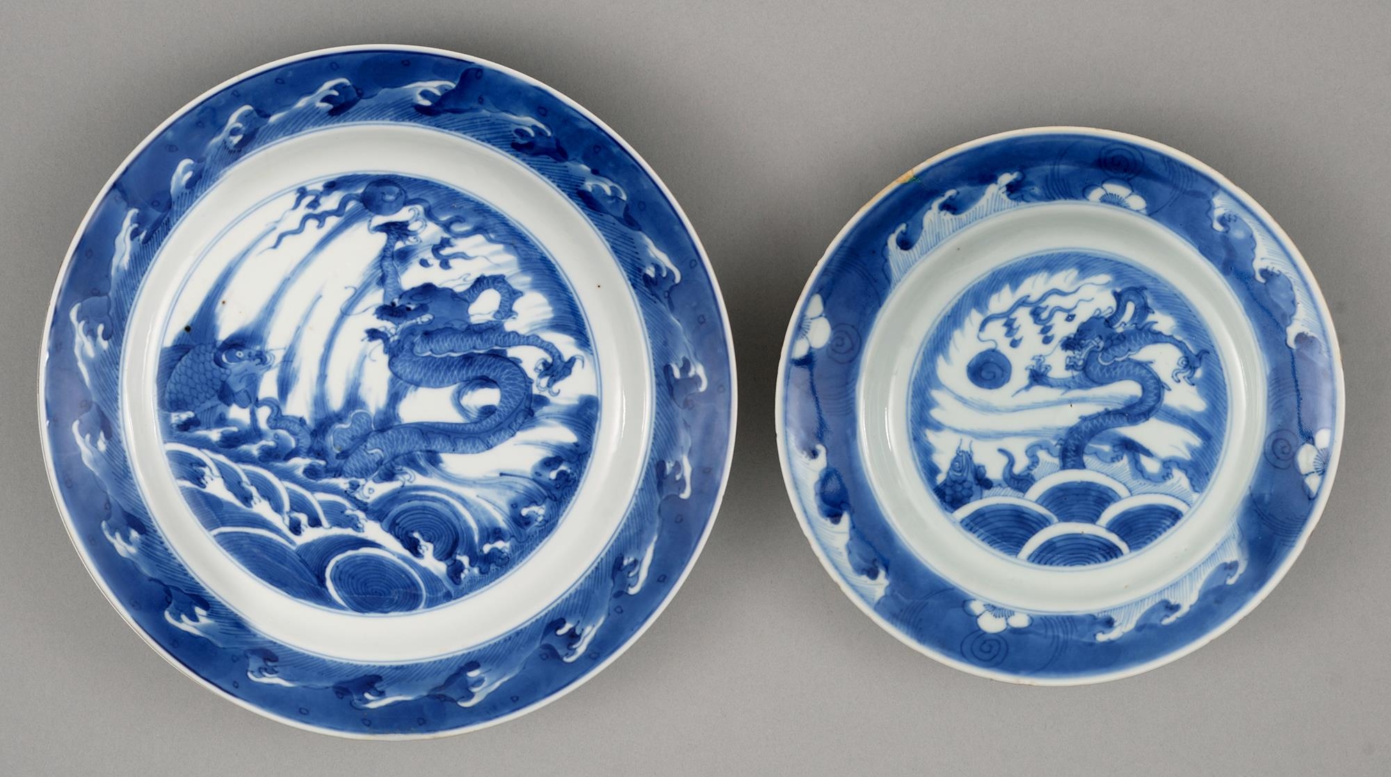 Two graduated Chinese blue and white plates, 18th c, painted with dragon and carp rising from