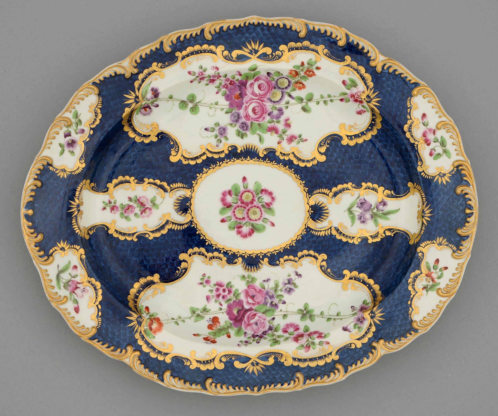 A Worcester scale blue ground dish, c1770, painted with flowers in gilt reserves and gilt feather