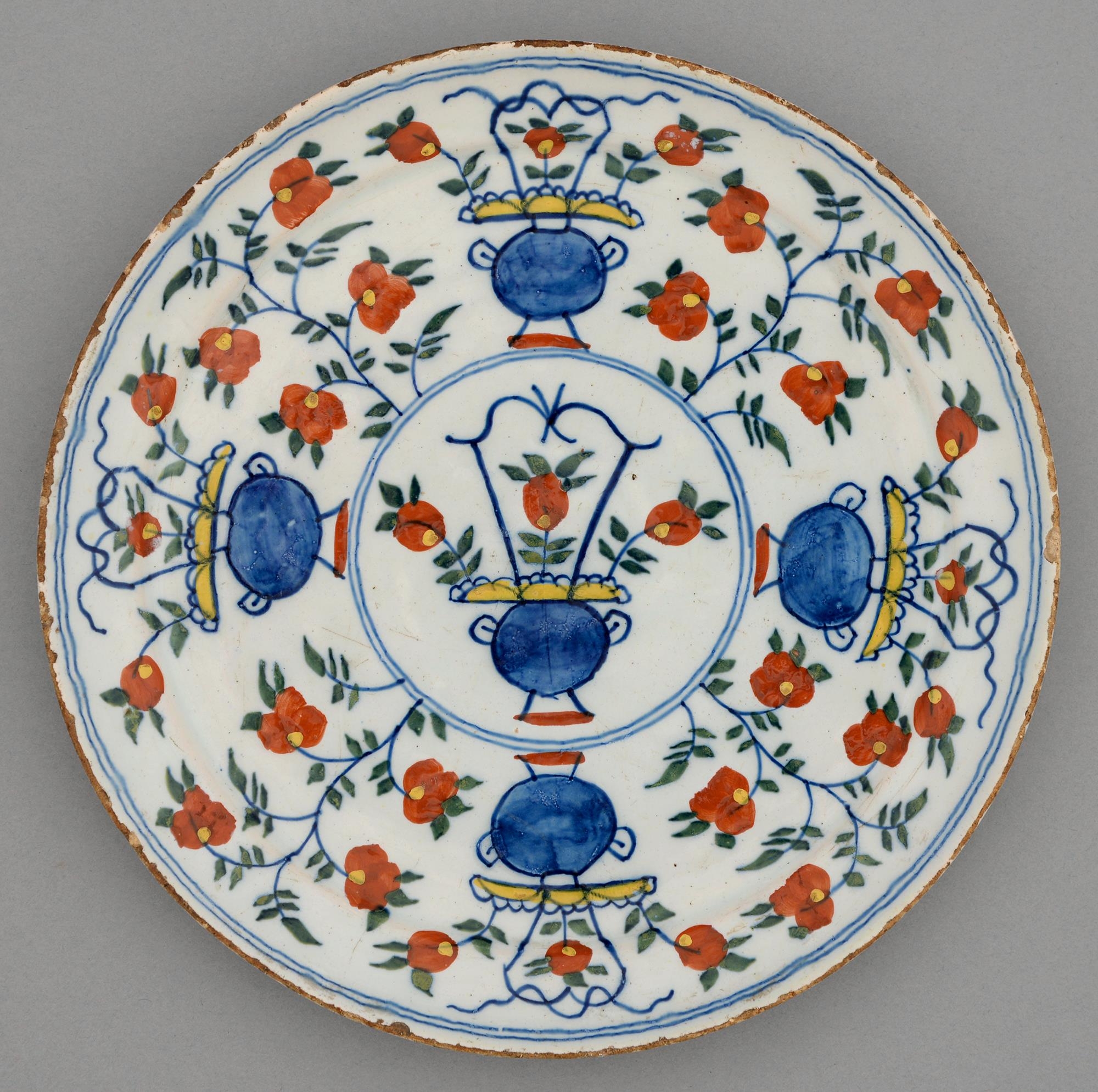 A Dutch Delftware plate, 18th c, painted in blue, green, red and yellow with a basket of flowers