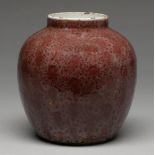 A Chinese flambe glazed jar, Qing dynasty, covered in a mottled uneven dull red glaze of orange peel