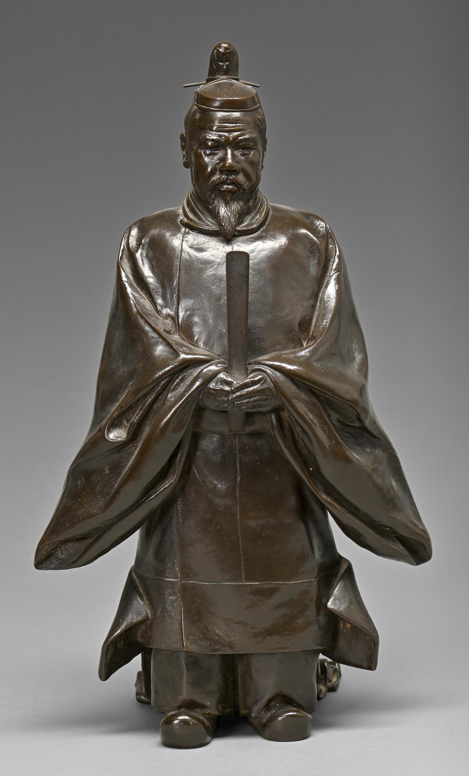 A Japanese bronze sculpture of  the Emperor Meiji dressed in Shinto style holding a ceremonial stuff