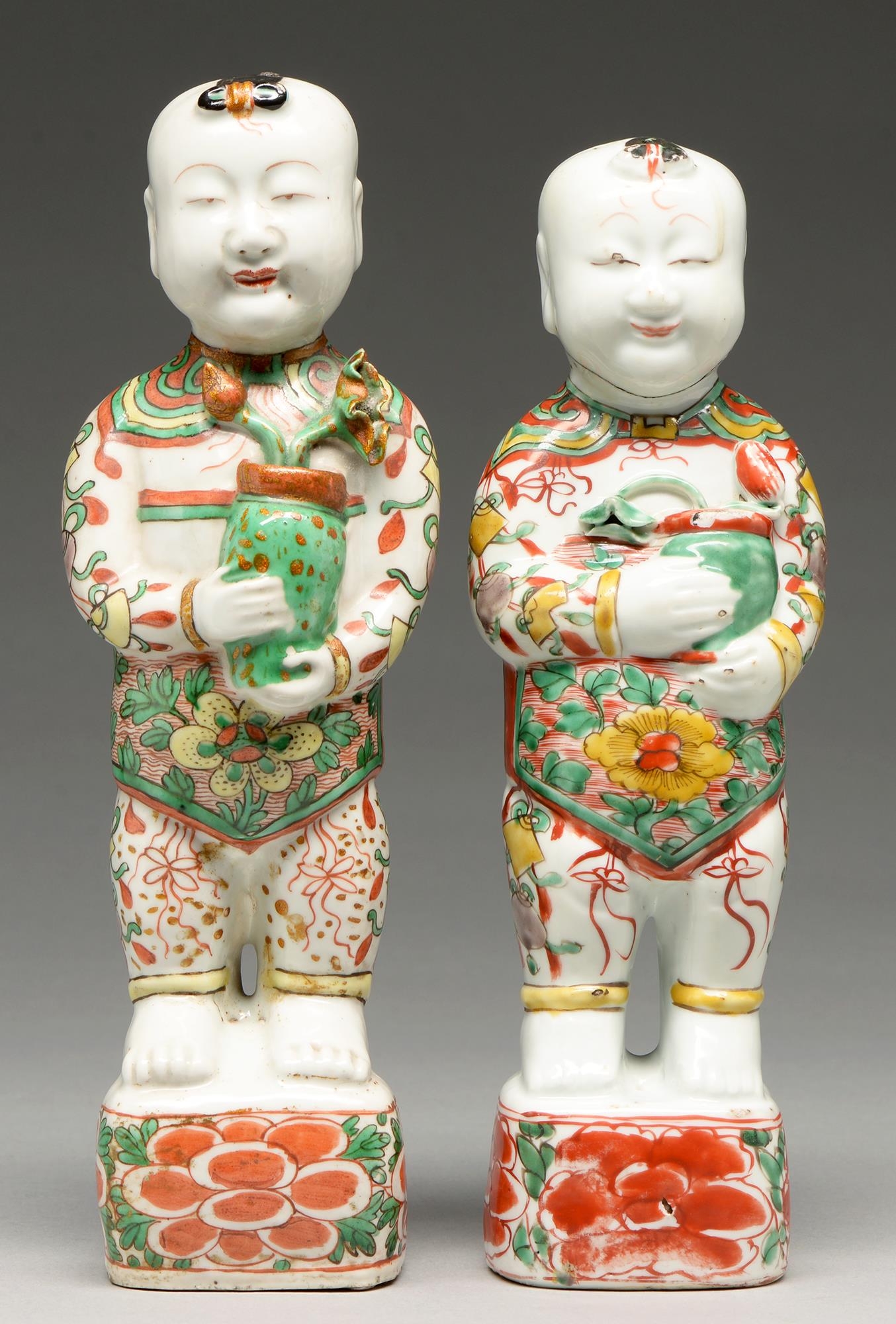 Two Chinese famille verte figures of boys, Kangxi period, each holding a pot of lotus, 27 and 29cm h