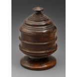 Treen. An oak mortar and cover, 17th c, turned with reeds, the stepped cover with low pointed