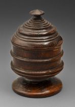 Treen. An oak mortar and cover, 17th c, turned with reeds, the stepped cover with low pointed