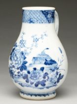 A Chinese blue and white jug, 18th c, painted with peony and prunus before a group of objects